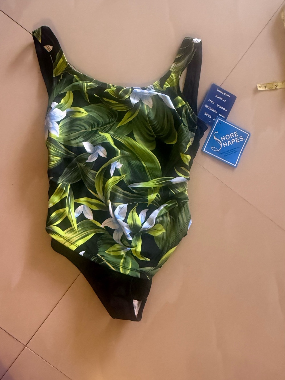 tropical floral one-piece swimsuit featuring a black, green, and white leaf-and